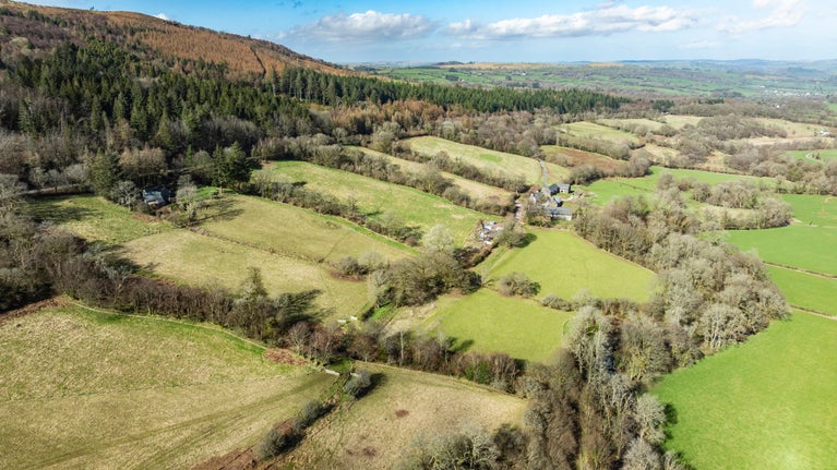 An aerial view of a valley of fields, hedgerows and woodlands at Ty Mawr Farm, Bannau Brycheiniog (Brecon Beacons)